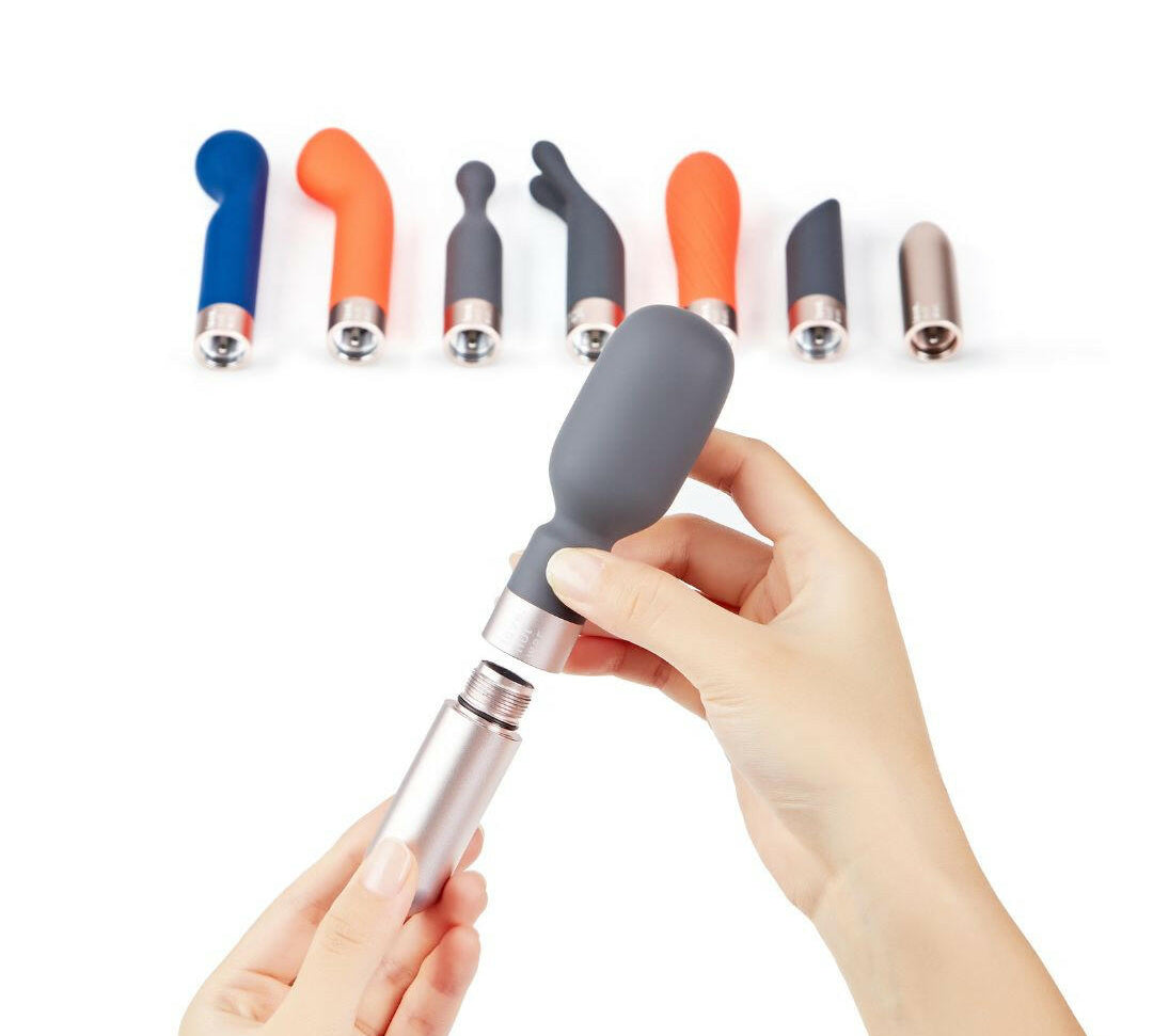 Hand holding Koi vibrator with all heads 